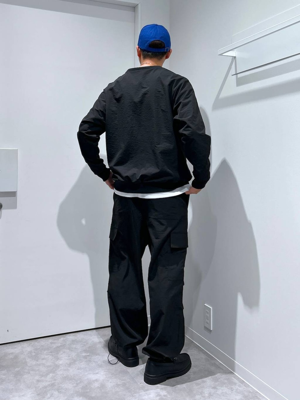 ホワイト系のTシャツ/カットソー、ブラック系のローファー、ブラック系のカーゴパンツを着用したメンズの冬コーディネートの2枚目の写真