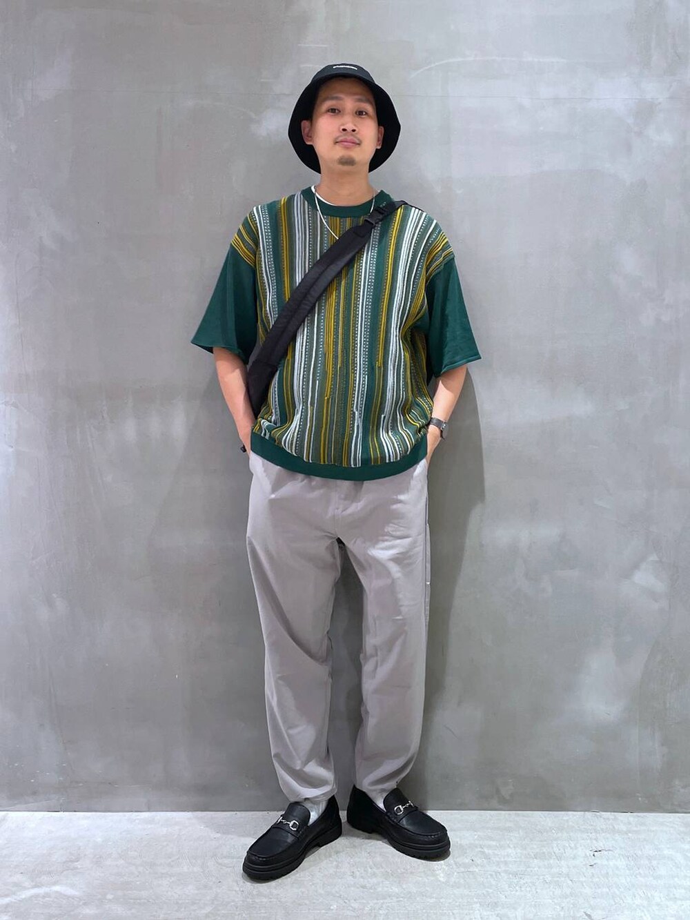 グレー系のTシャツ/カットソー、ブラック系のローファー、ブラック系のショルダーバッグを着用したメンズの夏コーディネートの2枚目の写真