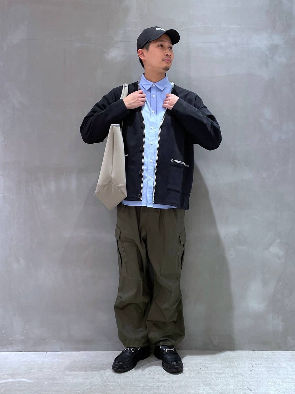 ブラック系のカーディガン/ボレロ、ブラック系のローファー、グリーン系のカーゴパンツを着用したメンズの冬コーディネートの2枚目の写真