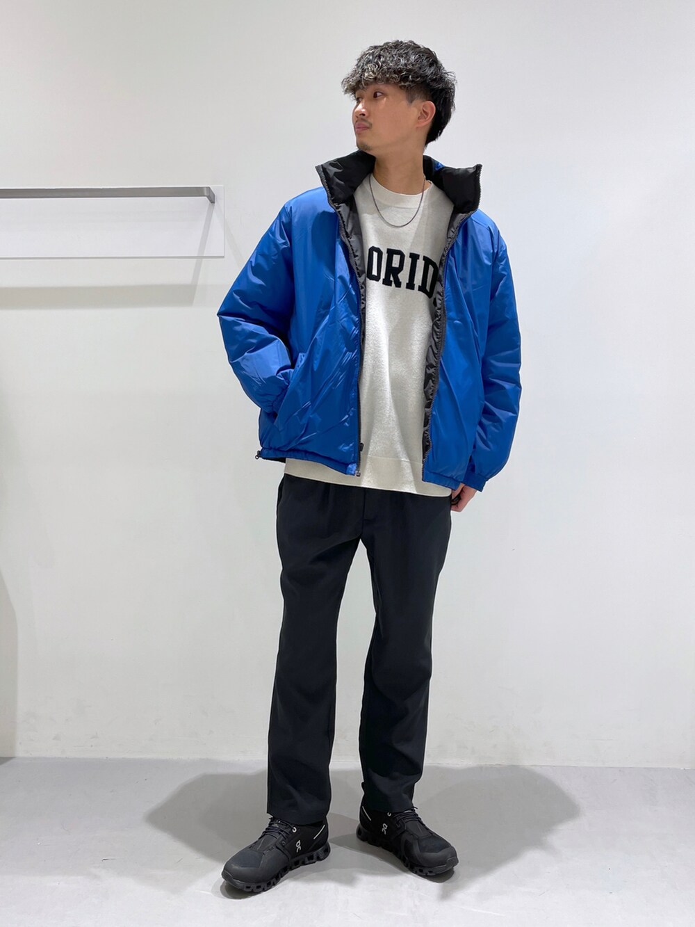 ブラック系のブルゾン、ブラック系のその他パンツ、ホワイト系のニット/セーターを着用したメンズの冬コーディネートの2枚目の写真