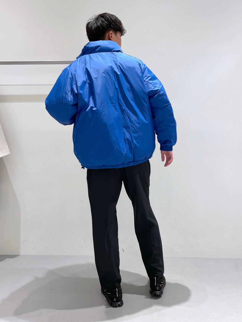 ブラック系のブルゾン、ブラック系のその他パンツ、ホワイト系のニット/セーターを着用したメンズの冬コーディネートの4枚目の写真