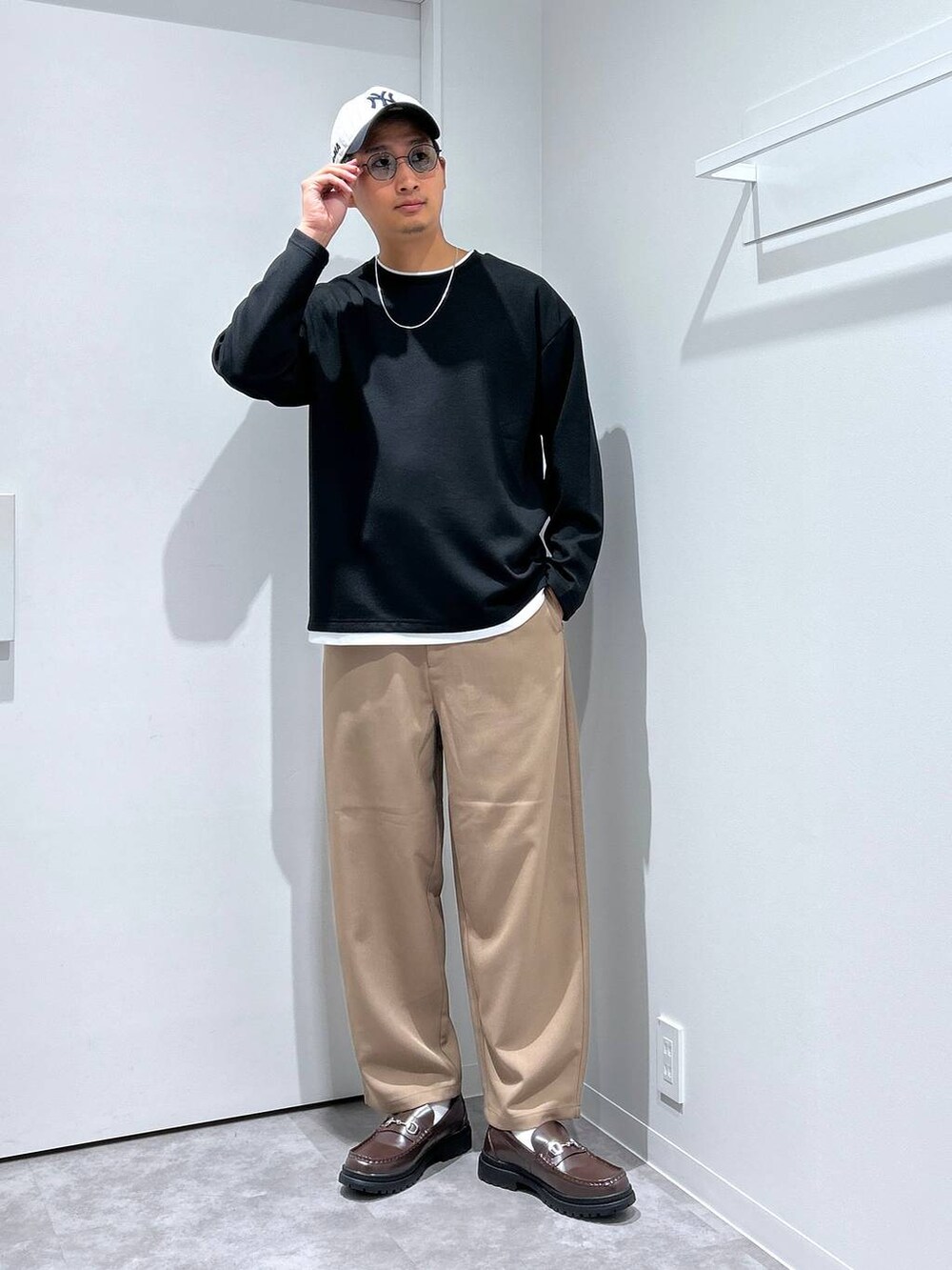 ブラック系のTシャツ/カットソー、ブラウン系のローファー、グリーン系のサングラスを着用したメンズの冬コーディネートの2枚目の写真