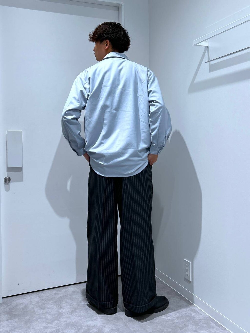 ホワイト系のTシャツ/カットソー、ブラック系のスラックスを着用したメンズの冬コーディネートの3枚目の写真