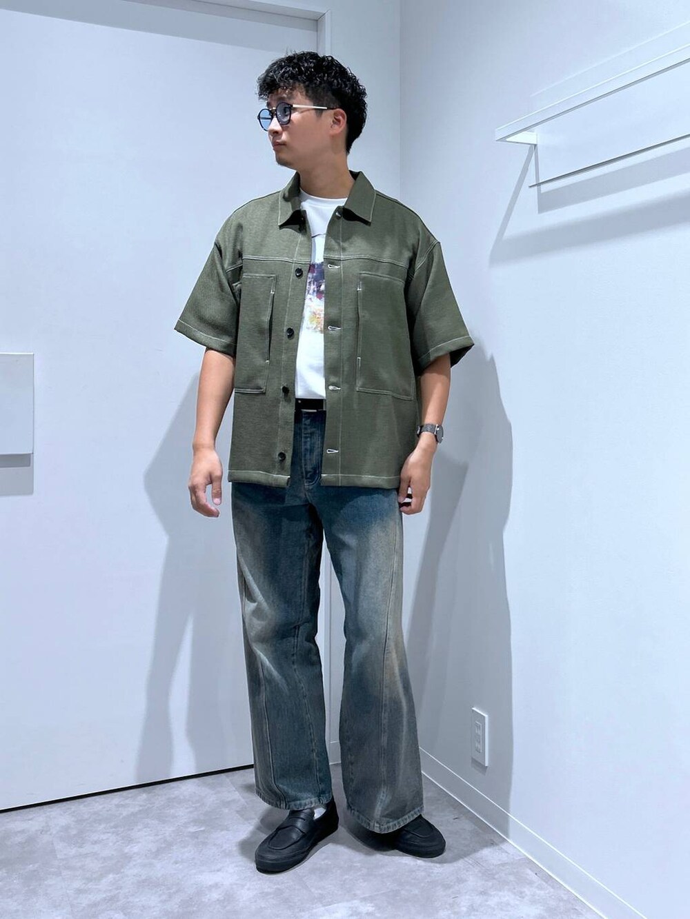 ブルー系のデニムパンツ、ホワイト系のTシャツ/カットソー、グリーン系のシャツ/ブラウスを着用したメンズの春コーディネートの2枚目の写真