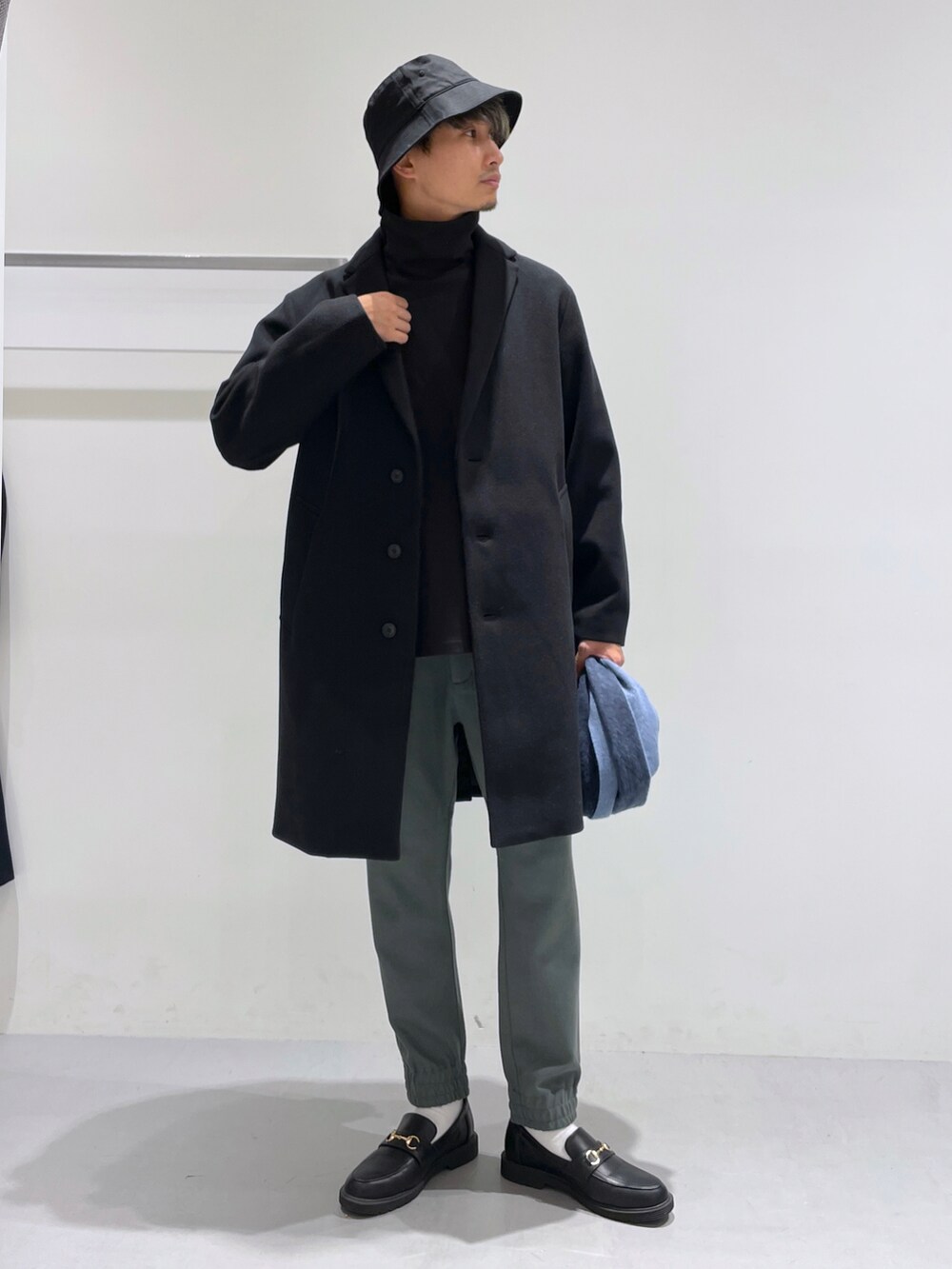 ブラック系のローファー、ブラック系のチェスターコート、ブラック系のTシャツ/カットソーを着用したメンズの冬コーディネートの2枚目の写真