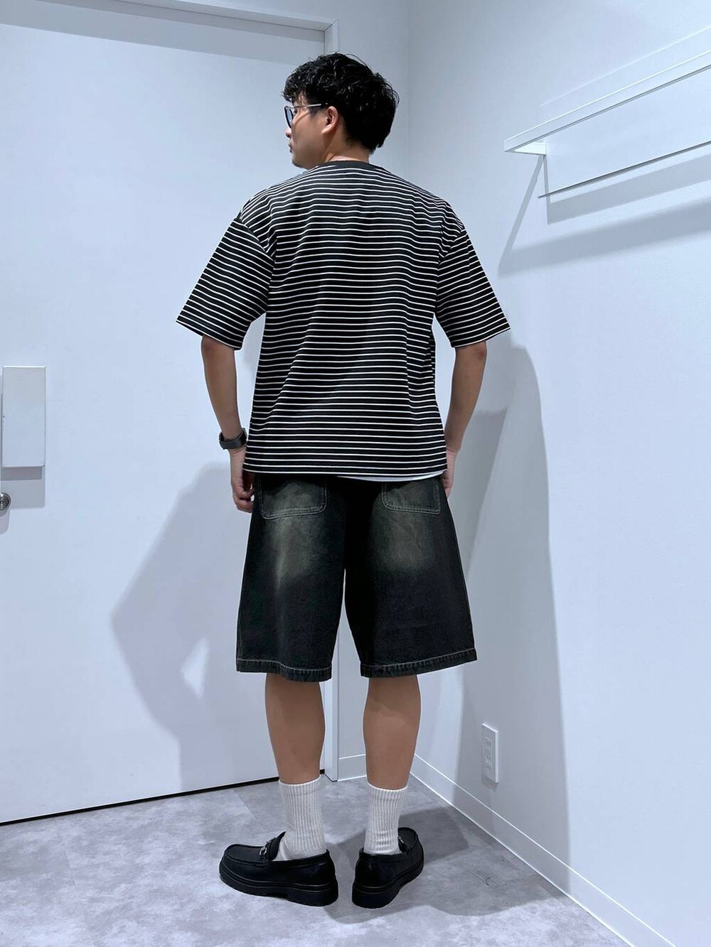 ブラック系のローファー、ブラック系のデニムパンツ、その他のTシャツ/カットソーを着用したメンズの春コーディネートの3枚目の写真