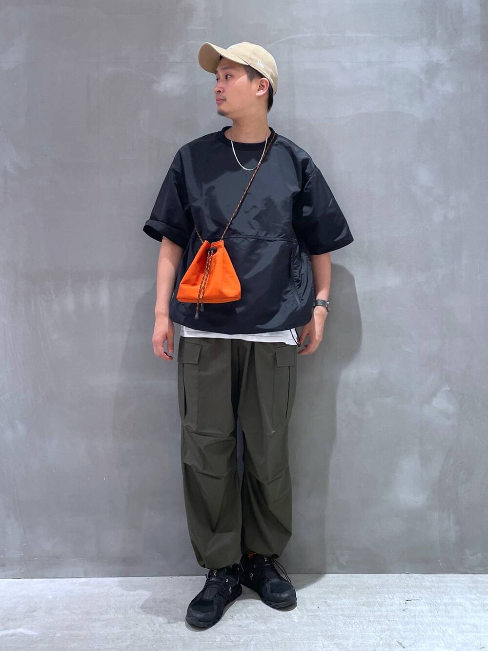 ホワイト系のTシャツ/カットソー、グリーン系のカーゴパンツ、オレンジ系のショルダーバッグを着用したメンズの夏コーディネートの4枚目の写真