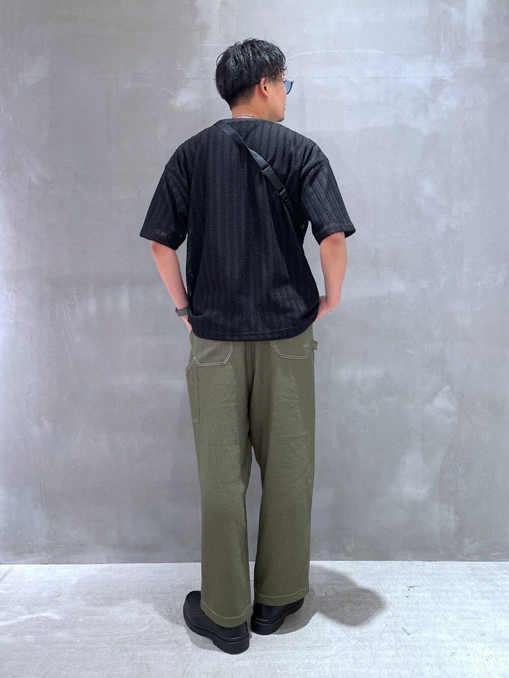 グリーン系のその他パンツ、ブラック系のローファー、ブラック系のTシャツ/カットソーを着用したメンズの春コーディネートの3枚目の写真