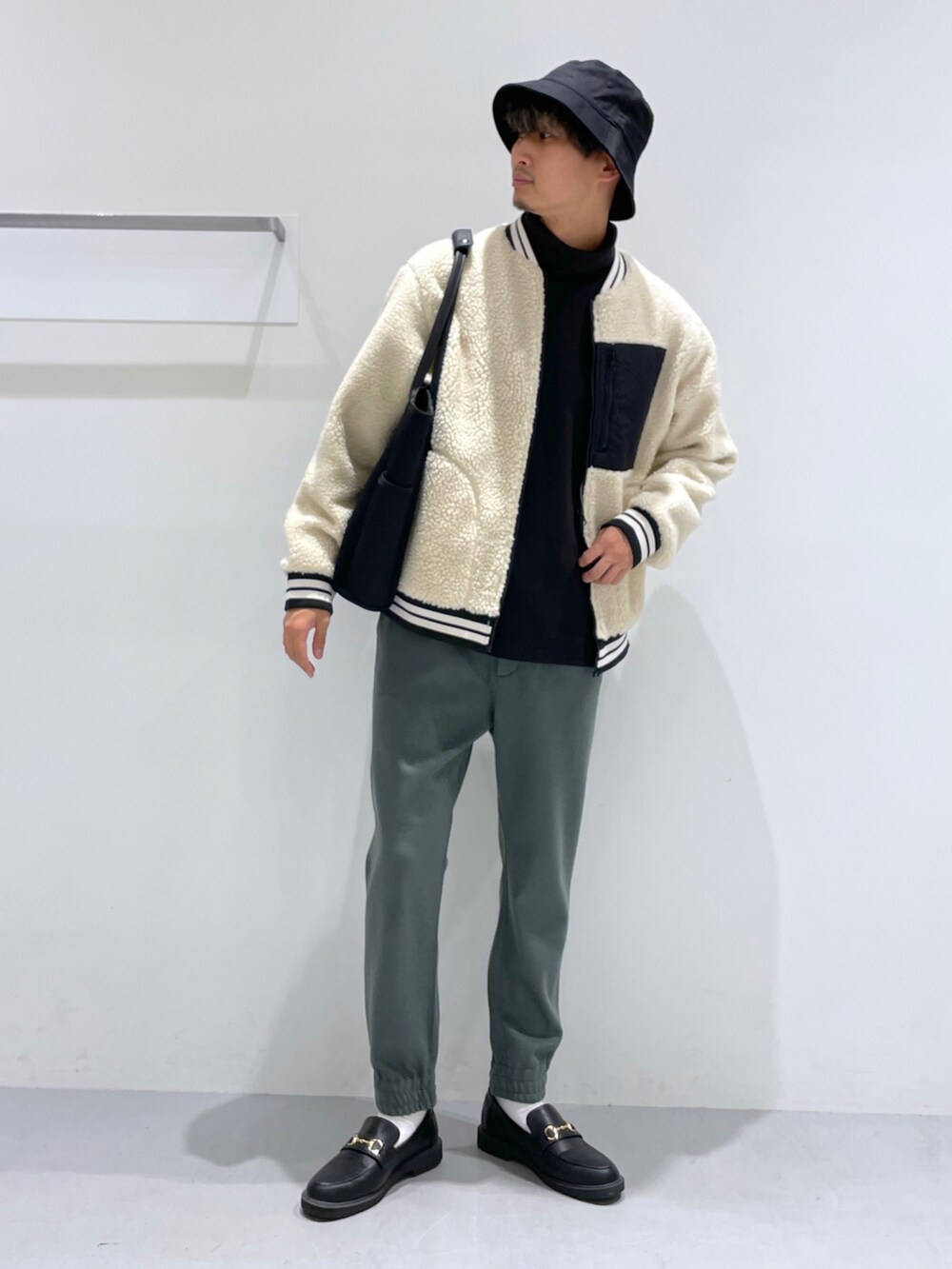 ホワイト系のブルゾン、ブラック系のローファー、ブラック系のTシャツ/カットソーを着用したメンズの冬コーディネートの2枚目の写真