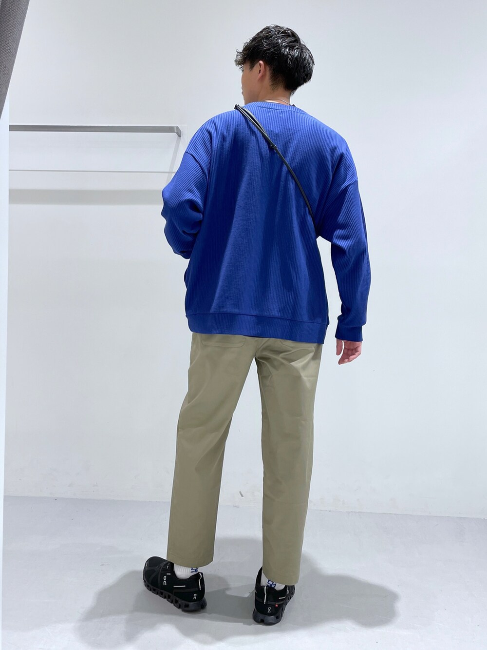 ブルー系のカーディガン/ボレロ、ベージュ系のチノパンツ、ブラック系のショルダーバッグを着用したメンズの冬コーディネートの2枚目の写真