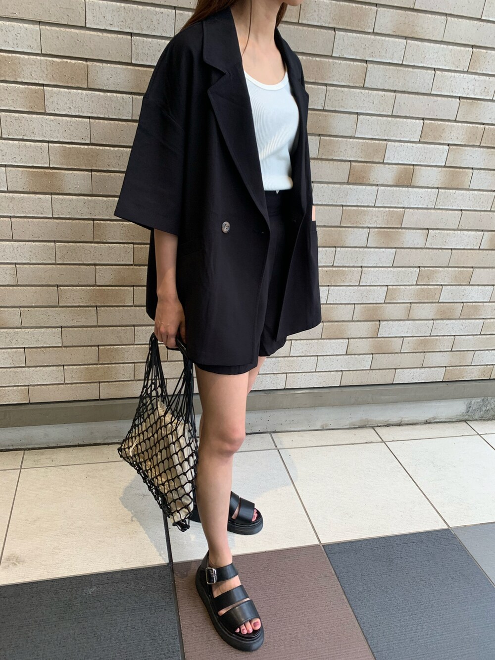ブラック系のサンダル、ブラック系のその他パンツ、ブラック系のテーラードジャケットを着用したレディースの夏コーディネートの2枚目の写真