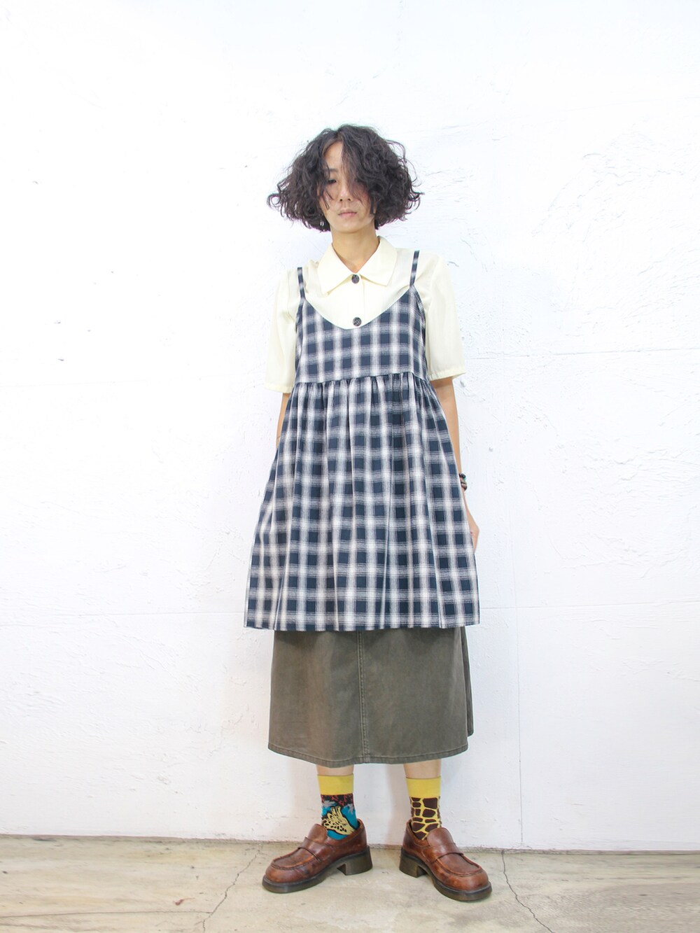 ベージュ系のシャツ/ブラウス、ブルー系のジャンパースカート、グリーン系のデニムスカートを着用したレディースの秋コーディネートの2枚目の写真