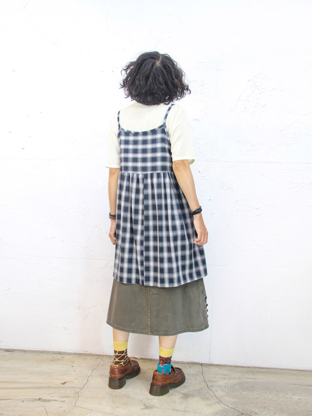 ベージュ系のシャツ/ブラウス、ブルー系のジャンパースカート、グリーン系のデニムスカートを着用したレディースの秋コーディネートの3枚目の写真