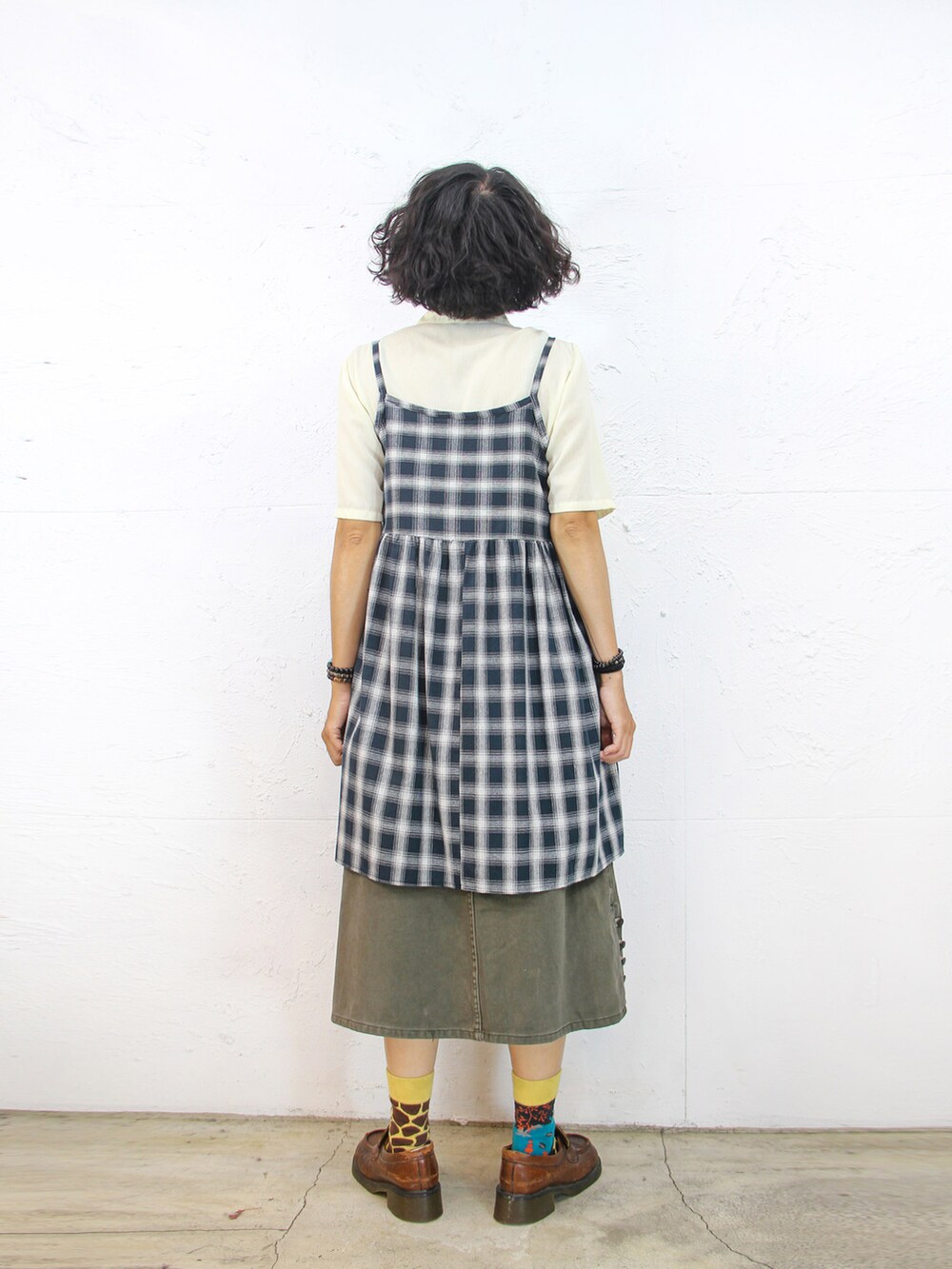 ベージュ系のシャツ/ブラウス、ブルー系のジャンパースカート、グリーン系のデニムスカートを着用したレディースの秋コーディネートの4枚目の写真