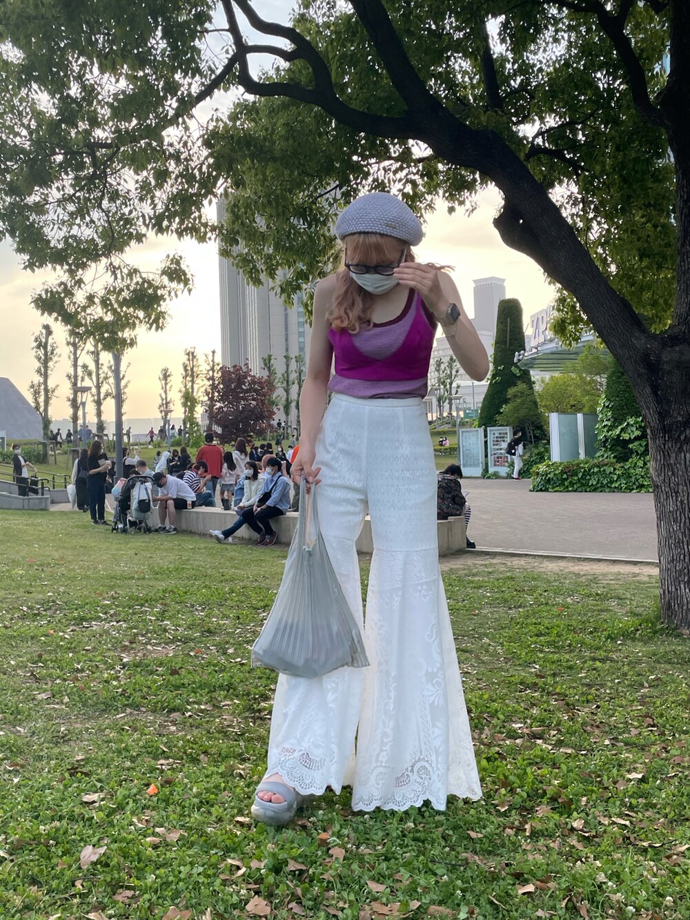 パープル系のキャミソール、ホワイト系のパンツ、パープル系のタンクトップを着用したレディースの春コーディネートの2枚目の写真