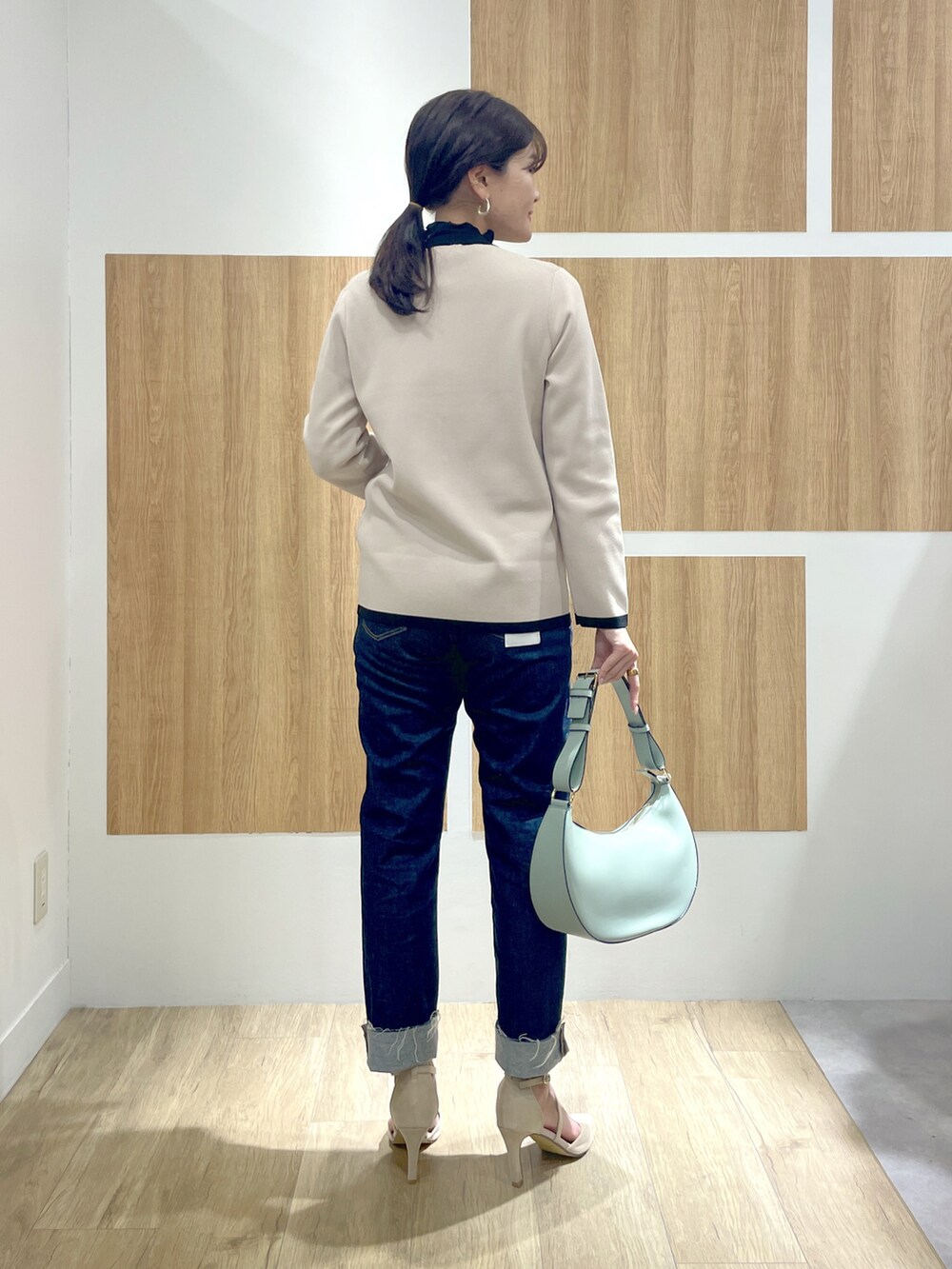 ブラック系のTシャツ/カットソー、ベージュ系のカーディガン/ボレロ、ブルー系のデニムパンツを着用したレディースの冬コーディネートの3枚目の写真