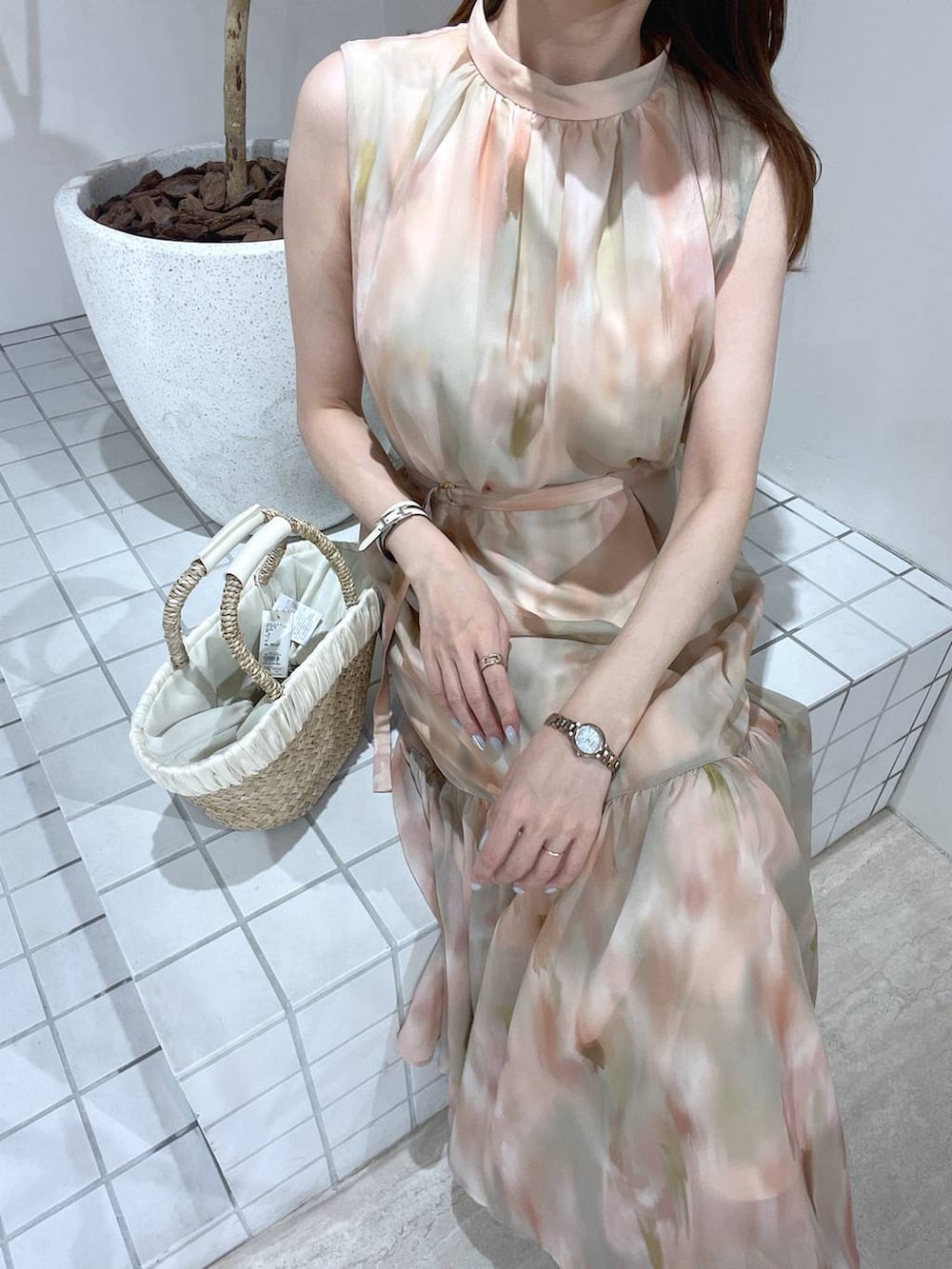 ベージュ系のかごバッグ、ブラウン系のワンピースを着用したレディースの夏コーディネートの3枚目の写真