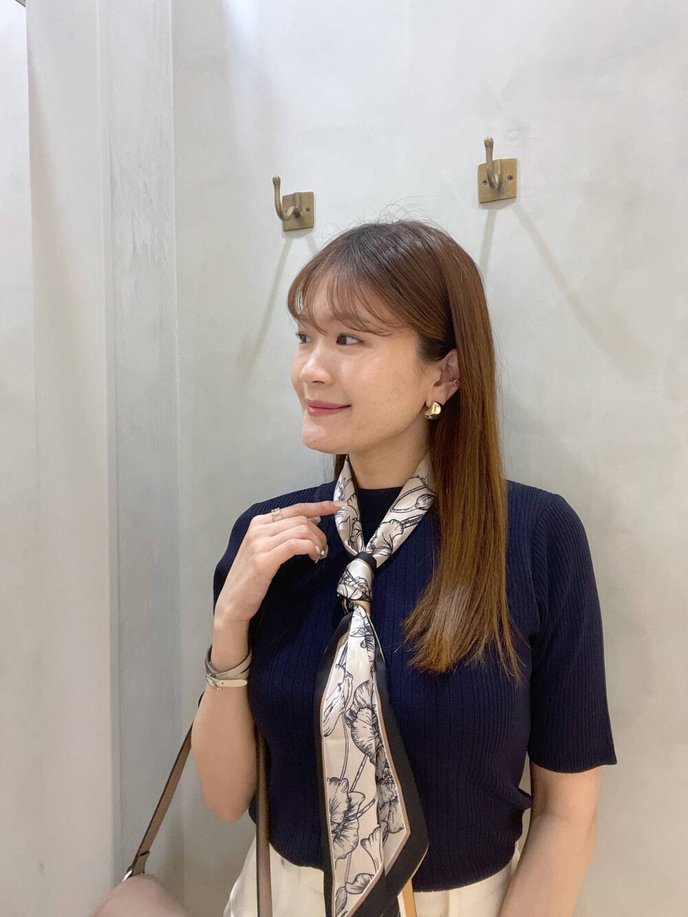 ホワイト系のサンダル、ブラウン系のハンドバッグ、ホワイト系のスカートを着用したレディースの春コーディネートの2枚目の写真