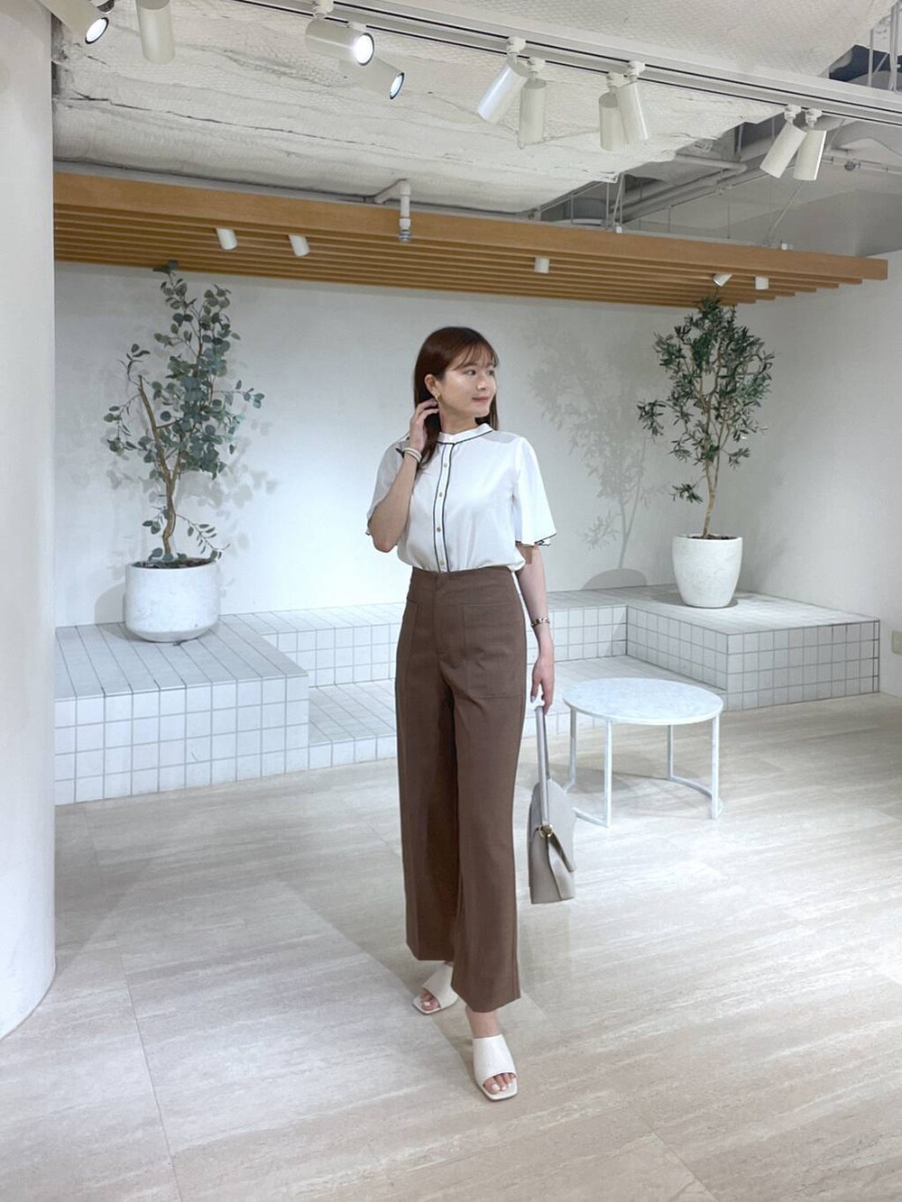 ホワイト系のサンダル、ホワイト系のハンドバッグ、ブラウン系のその他パンツを着用したレディースの夏コーディネートの4枚目の写真