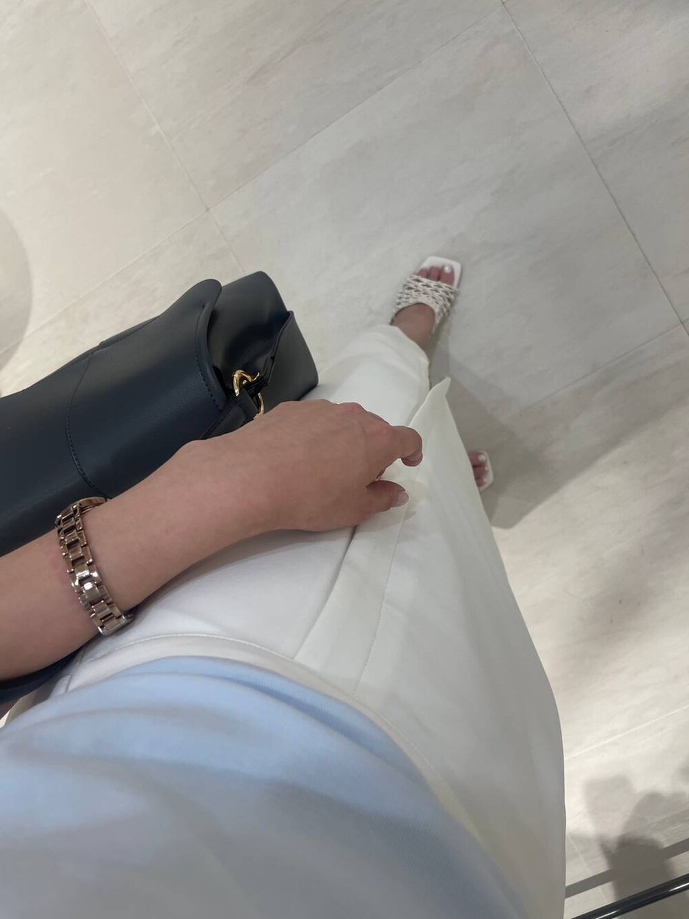 ホワイト系のサンダル、ブルー系のTシャツ/カットソー、ベージュ系のスカートを着用したレディースの春コーディネートの2枚目の写真