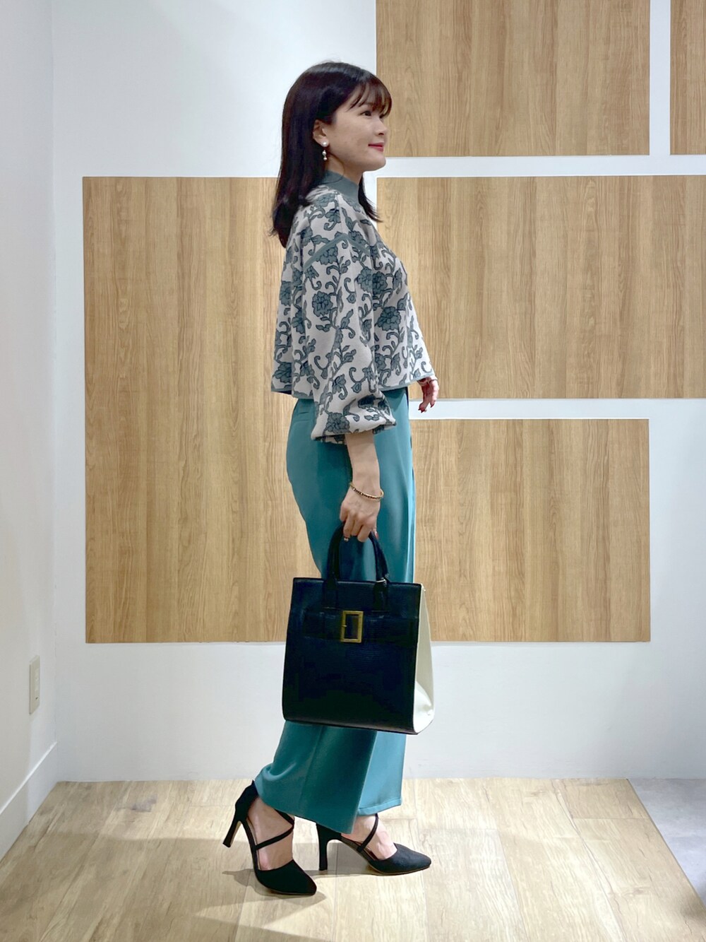 グリーン系のニット/セーター、グリーン系のその他パンツ、ブラック系のトートバッグを着用したレディースの秋コーディネートの2枚目の写真