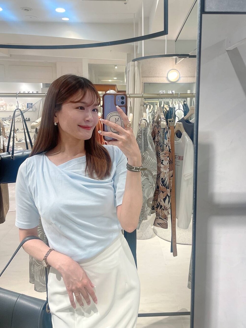 ホワイト系のサンダル、ブルー系のTシャツ/カットソー、ベージュ系のスカートを着用したレディースの春コーディネートの4枚目の写真