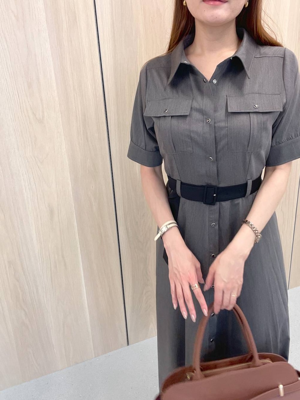 ブラック系のサンダル、グレー系のワンピース、ブラウン系のボストンバッグを着用したレディースの夏コーディネートの3枚目の写真