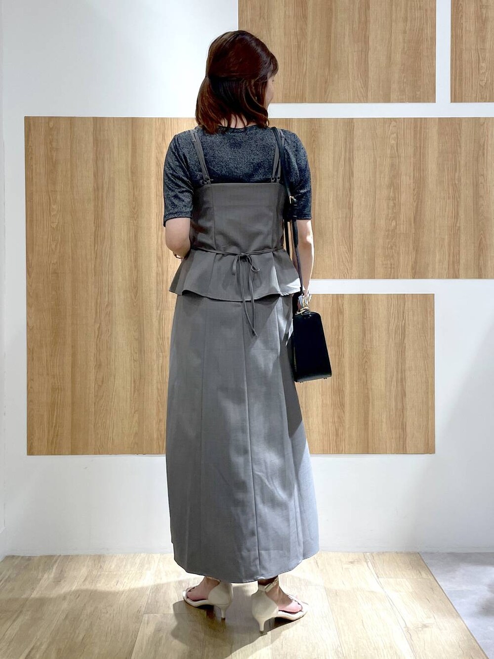 ホワイト系のサンダル、ブラック系のかごバッグ、ブラック系のTシャツ/カットソーを着用したレディースの夏コーディネートの4枚目の写真