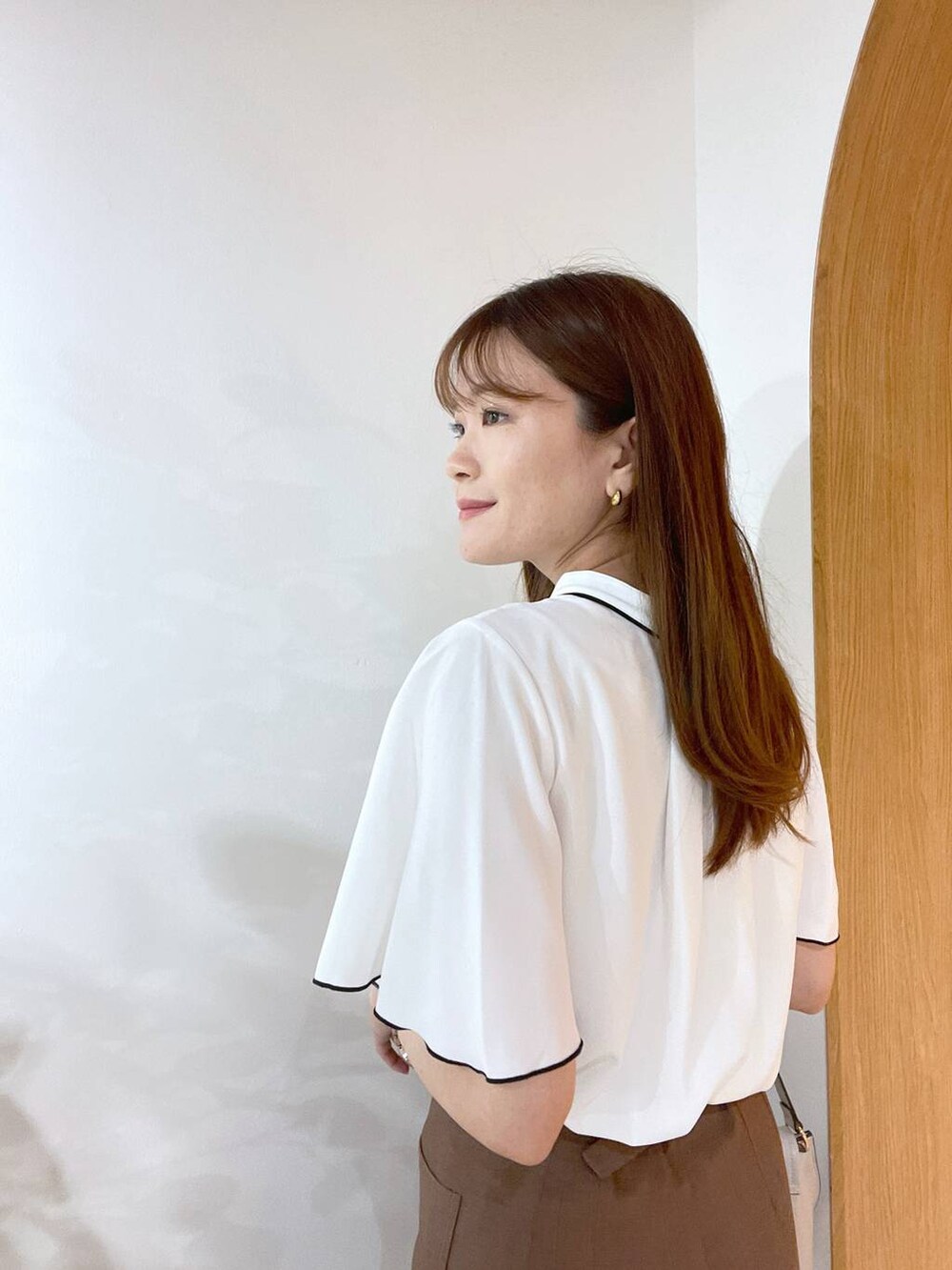 ホワイト系のサンダル、ホワイト系のハンドバッグ、ブラウン系のその他パンツを着用したレディースの夏コーディネートの2枚目の写真