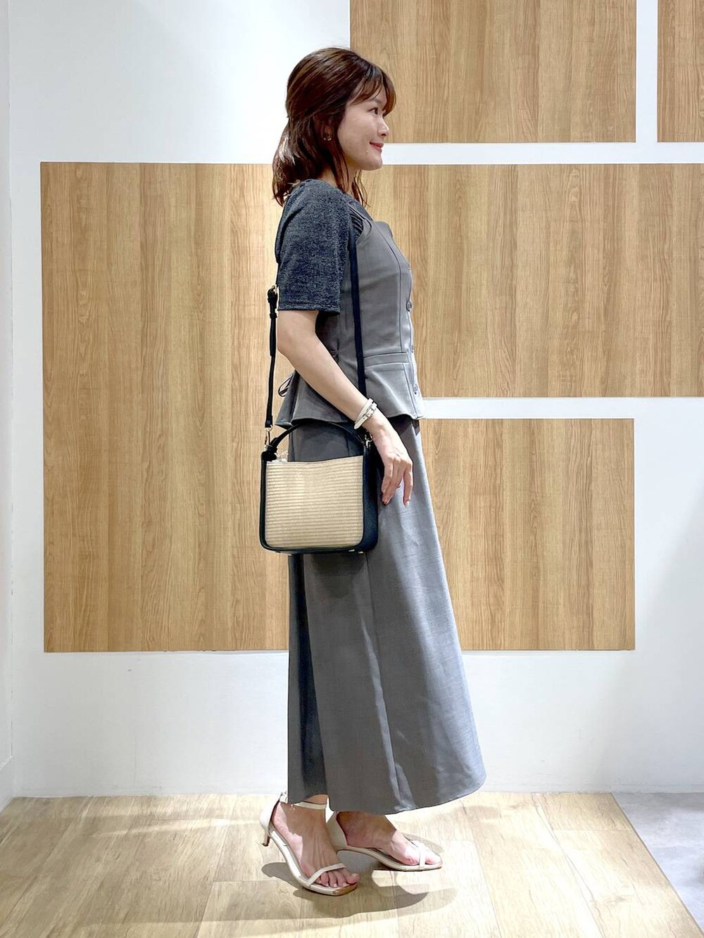 ホワイト系のサンダル、ブラック系のかごバッグ、ブラック系のTシャツ/カットソーを着用したレディースの夏コーディネートの3枚目の写真