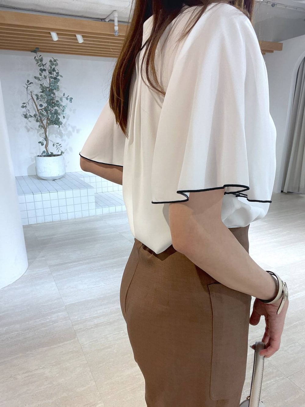 ホワイト系のサンダル、ホワイト系のハンドバッグ、ブラウン系のその他パンツを着用したレディースの夏コーディネートの5枚目の写真