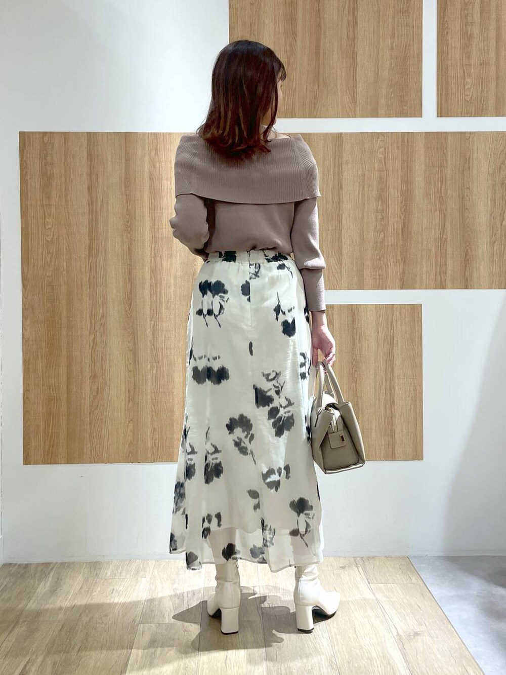 ホワイト系のブーツ、ベージュ系のハンドバッグ、ホワイト系のスカートを着用したレディースの冬コーディネートの4枚目の写真