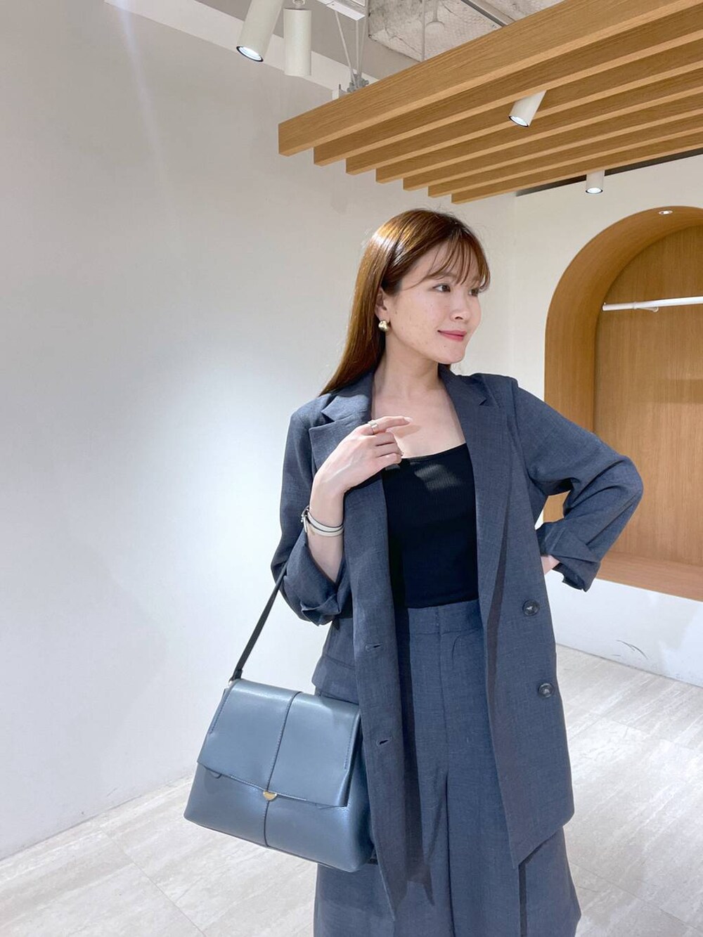 ブラック系のキャミソール、ブラック系のサンダル、グレー系のハンドバッグを着用したレディースの春コーディネートの2枚目の写真