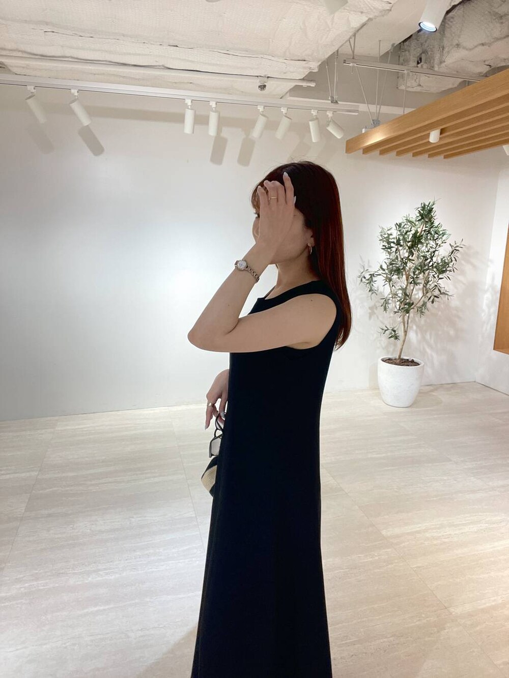 ブラック系のトートバッグ、ブラック系のサンダル、ブラック系のワンピースを着用したレディースの夏コーディネートの2枚目の写真