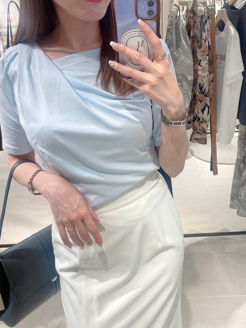 ホワイト系のサンダル、ブルー系のTシャツ/カットソー、ベージュ系のスカートを着用したレディースの春コーディネートの3枚目の写真