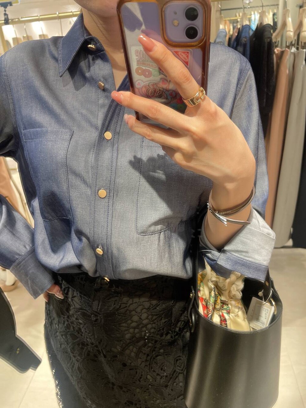 ブラック系のショルダーバッグ、ブルー系のシャツ/ブラウス、ブラック系のスカートを着用したレディースの春コーディネートの2枚目の写真