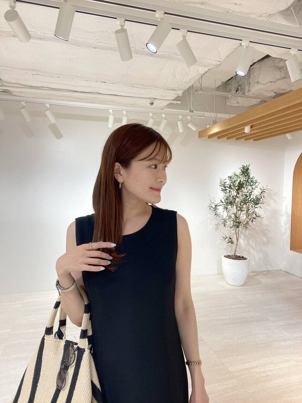 ブラック系のトートバッグ、ブラック系のサンダル、ブラック系のワンピースを着用したレディースの夏コーディネートの3枚目の写真