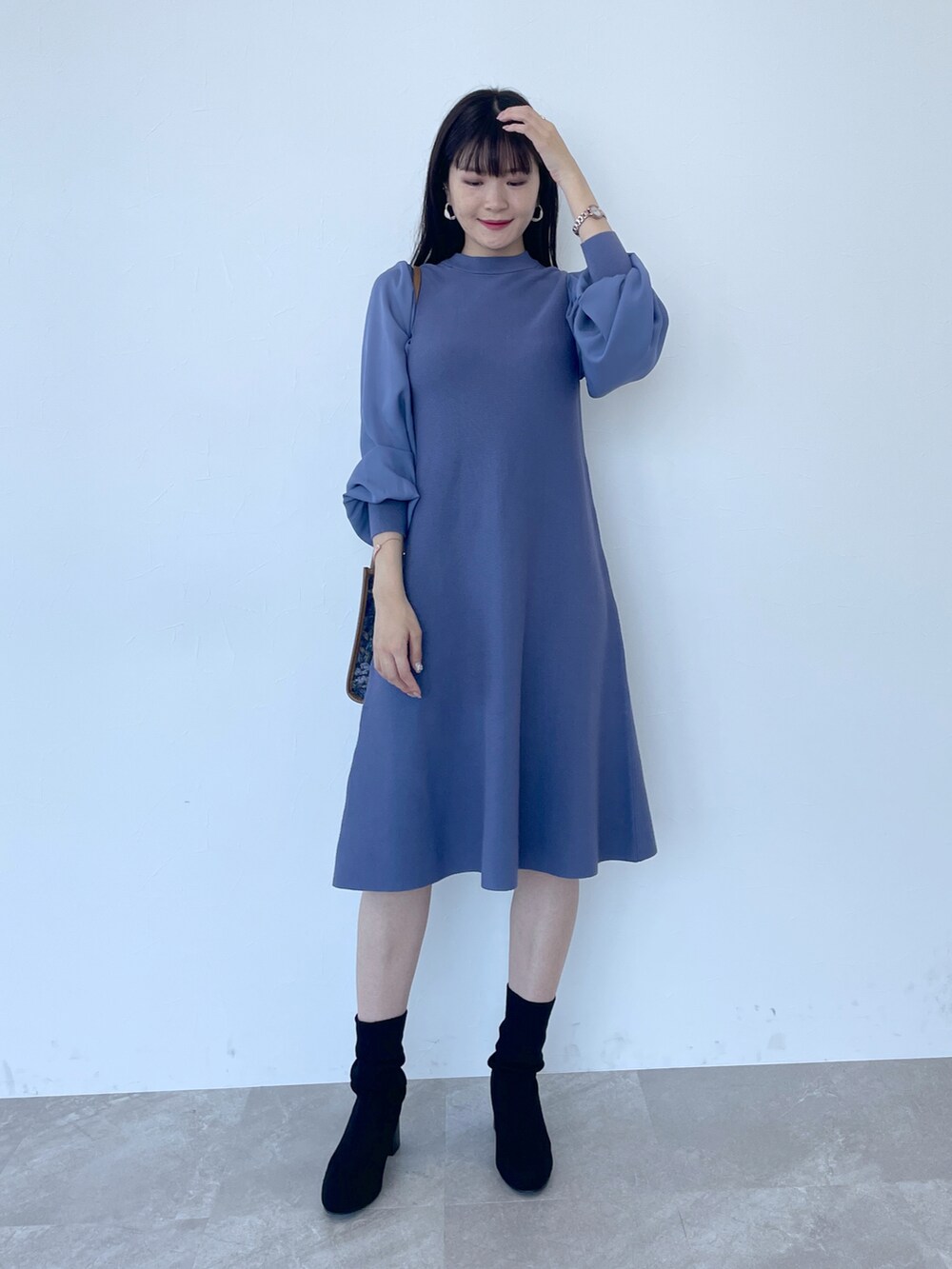 ブルー系のワンピース、ブルー系のショルダーバッグ、ブラック系のブーツを着用したレディースの夏コーディネートの2枚目の写真
