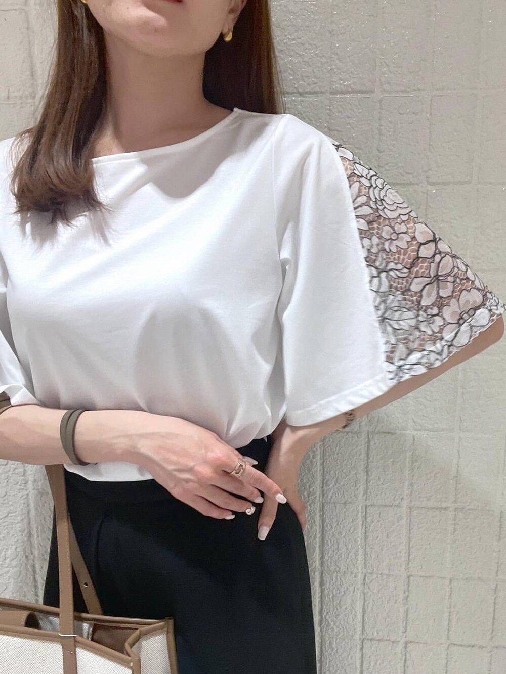 イエロー系のトートバッグ、ブラック系のスラックス、ホワイト系のTシャツ/カットソーを着用したレディースの春コーディネートの4枚目の写真