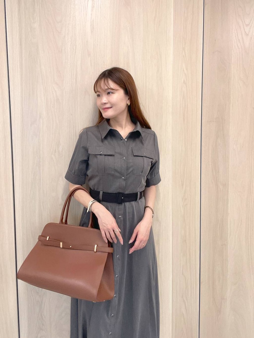 ブラック系のサンダル、グレー系のワンピース、ブラウン系のボストンバッグを着用したレディースの夏コーディネートの2枚目の写真