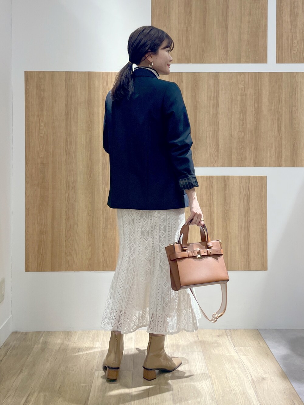 ブルー系のテーラードジャケット、その他のニット/セーター、ホワイト系のスカートを着用したレディースの冬コーディネートの3枚目の写真