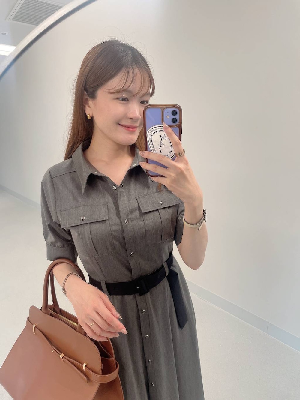 ブラック系のサンダル、グレー系のワンピース、ブラウン系のボストンバッグを着用したレディースの夏コーディネートの4枚目の写真