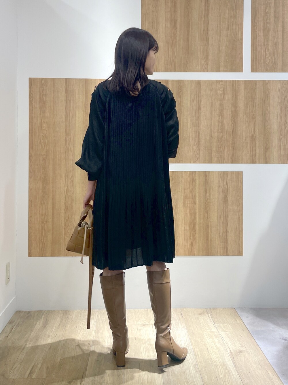 ブラック系のワンピース、ブラウン系のブーツ、ブラウン系のショルダーバッグを着用したレディースの冬コーディネートの4枚目の写真