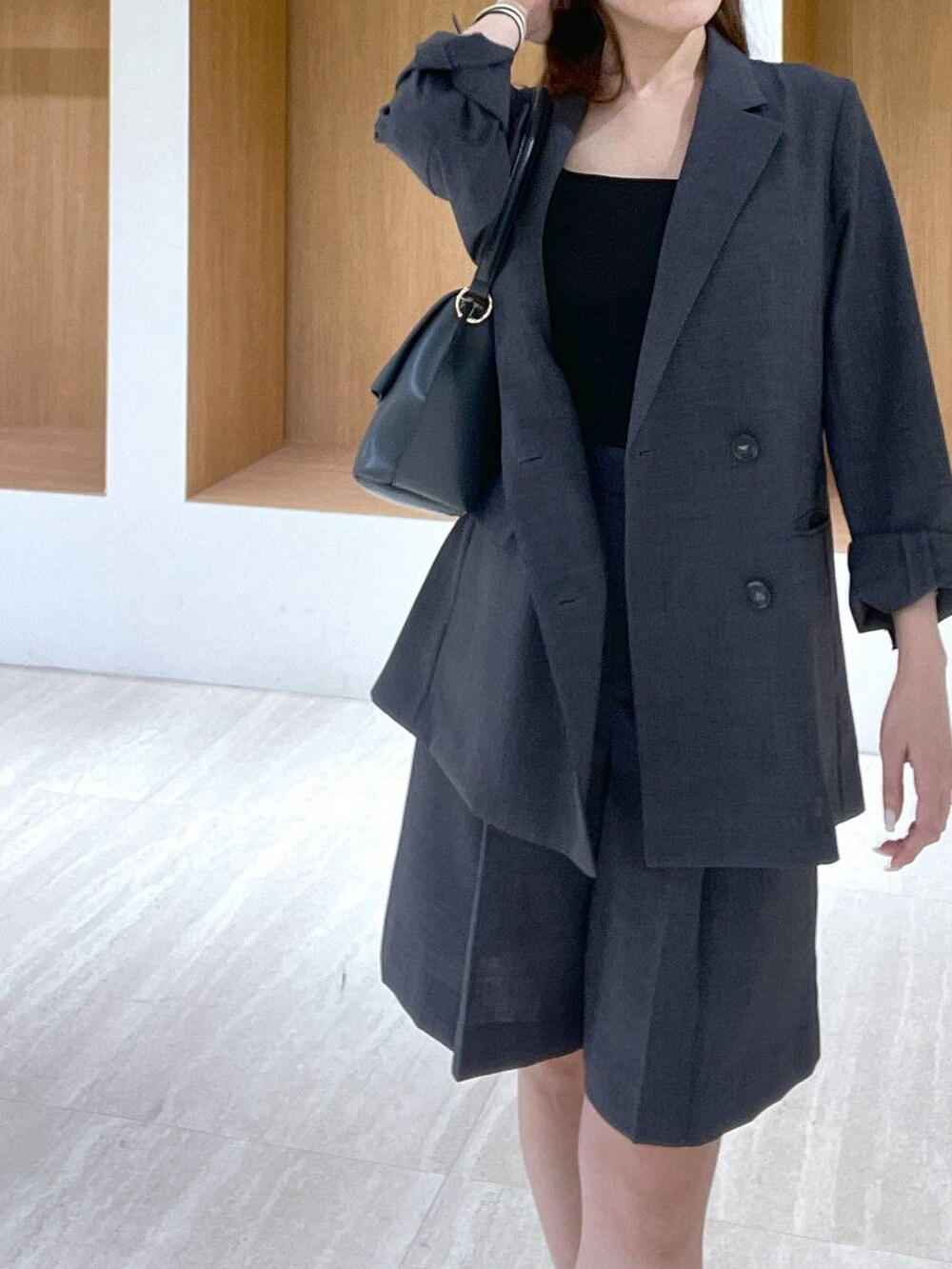 ブラック系のキャミソール、ブラック系のサンダル、グレー系のハンドバッグを着用したレディースの春コーディネートの5枚目の写真