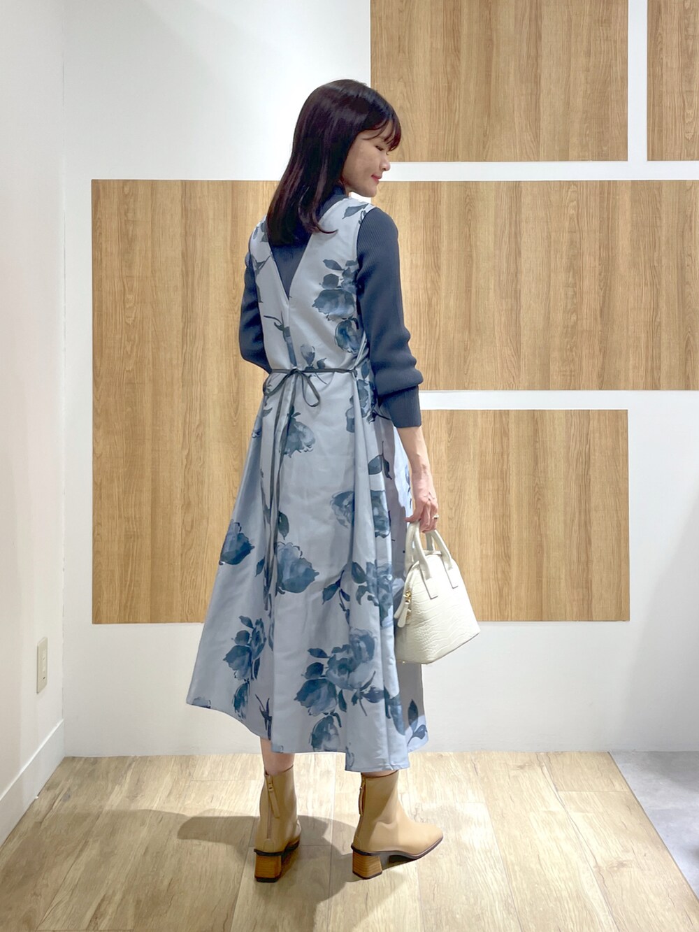 ブルー系のワンピース、ホワイト系のショルダーバッグ、グレー系のパンプスを着用したレディースの冬コーディネートの3枚目の写真
