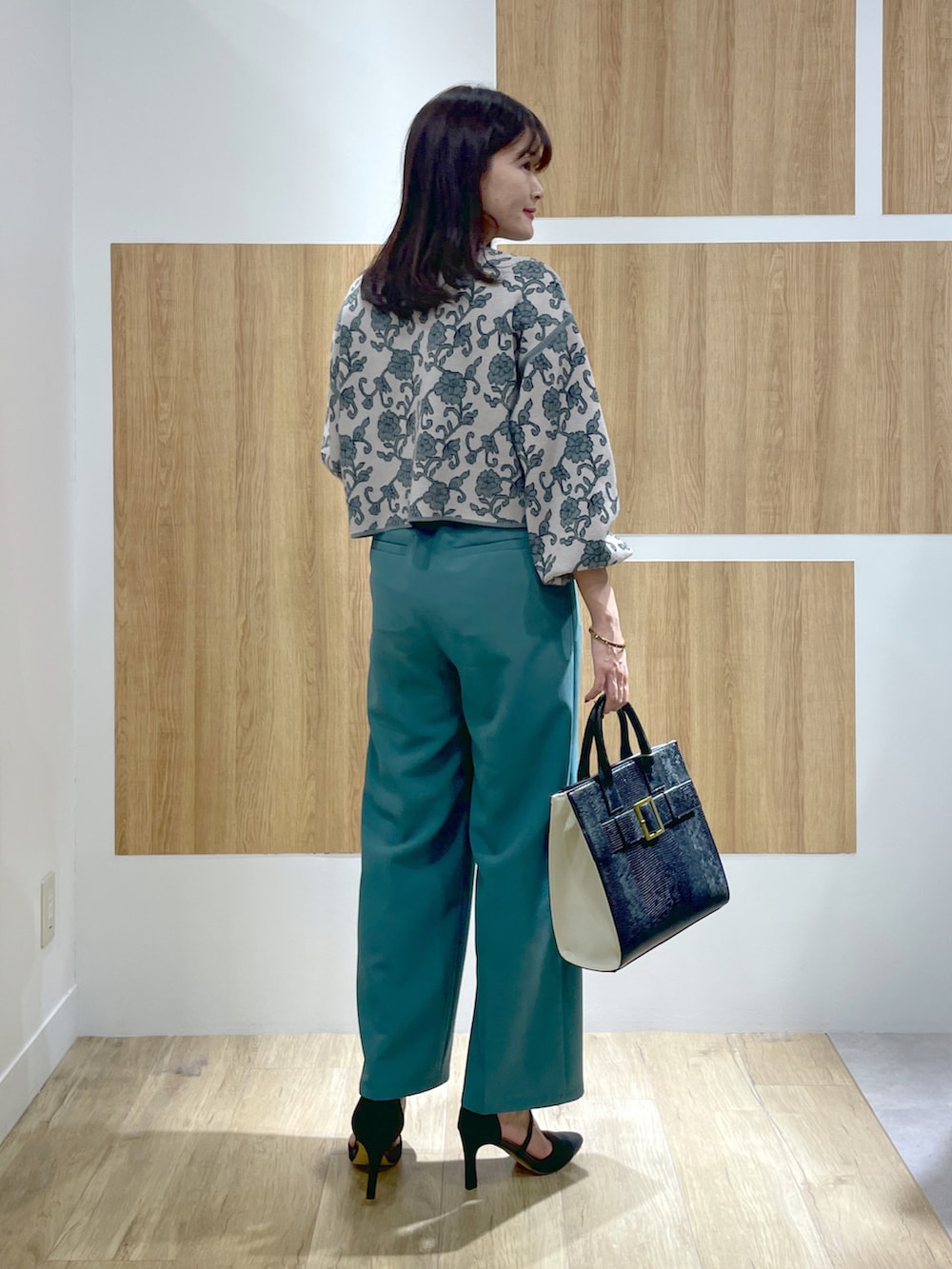 グリーン系のニット/セーター、グリーン系のその他パンツ、ブラック系のトートバッグを着用したレディースの秋コーディネートの3枚目の写真