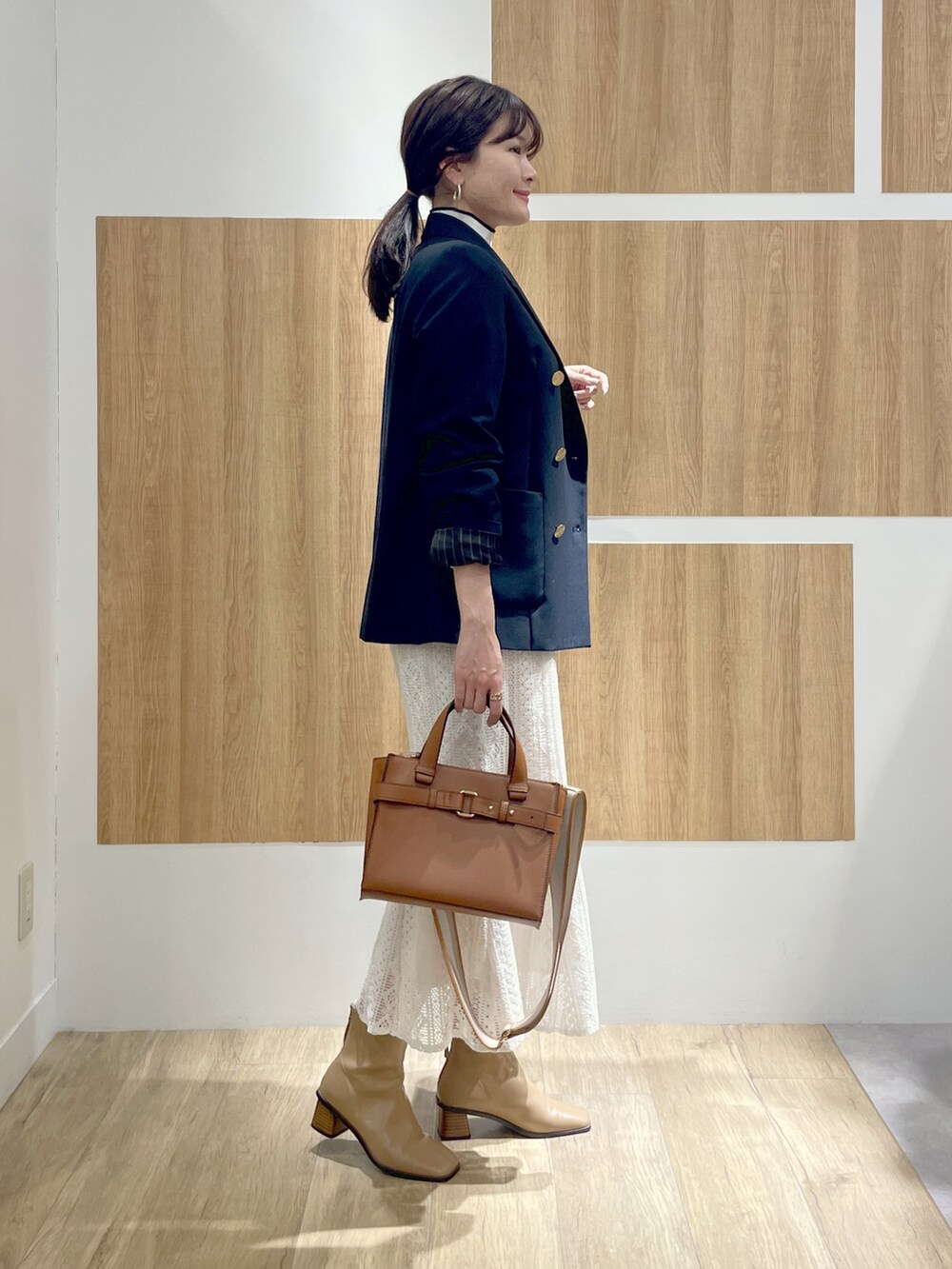 ブルー系のテーラードジャケット、その他のニット/セーター、ホワイト系のスカートを着用したレディースの冬コーディネートの2枚目の写真