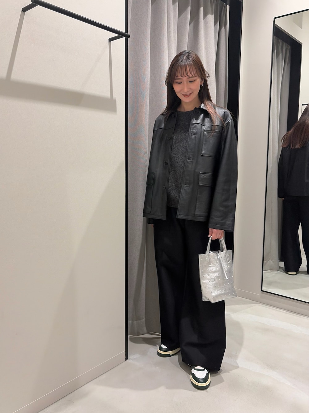 グリーン系のニット/セーター、ブラック系のその他パンツ、シルバー系のトートバッグを着用したレディースの冬コーディネートの2枚目の写真