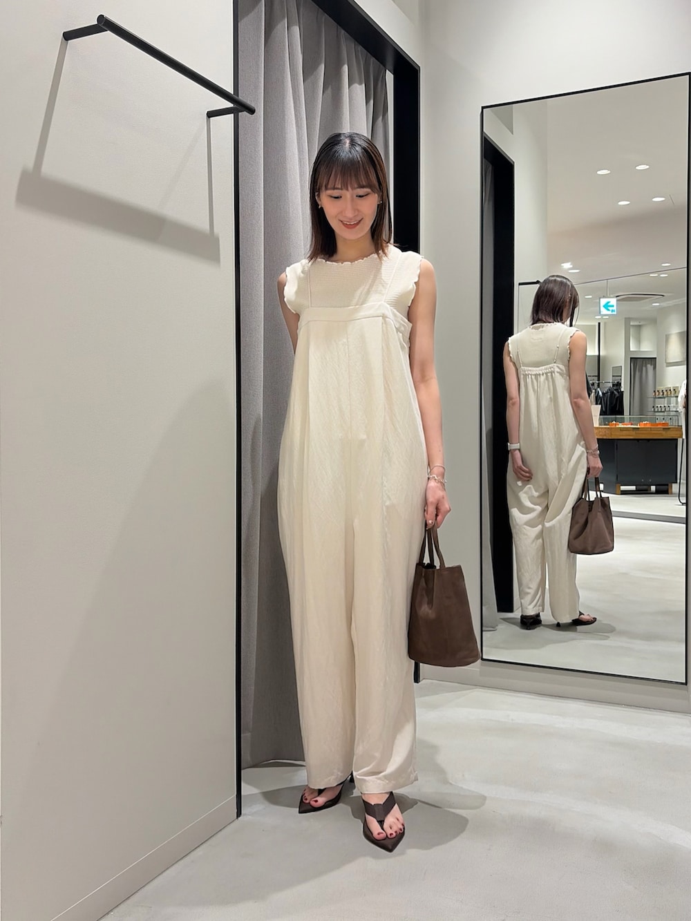 ホワイト系のその他パンツ、ベージュ系のタンクトップ、ブラウン系のサンダルを着用したレディースの春コーディネートの2枚目の写真