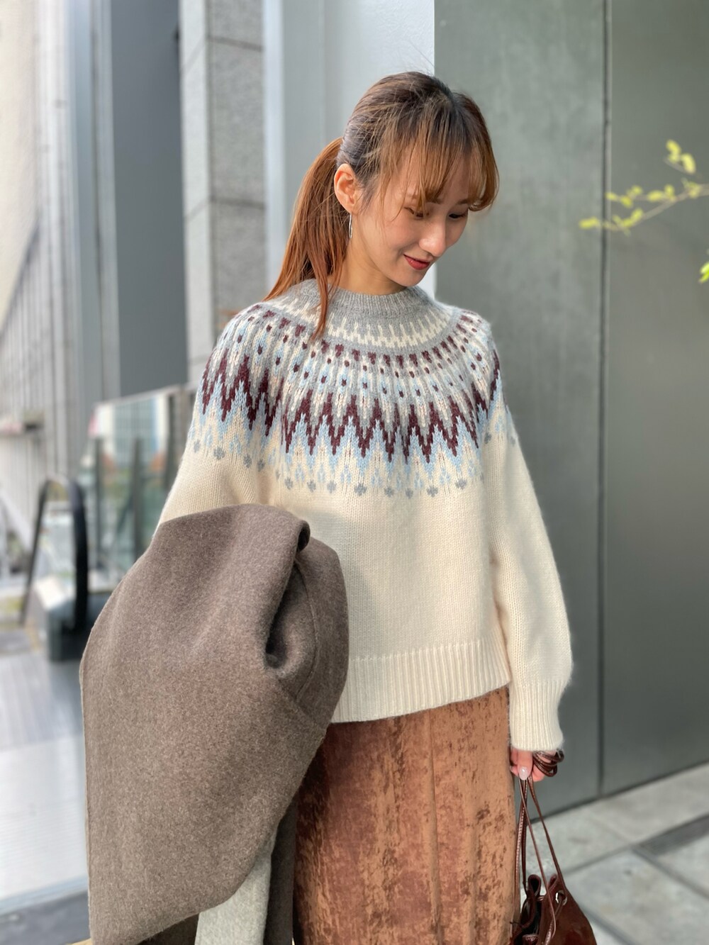 グレー系のその他アウター、グレー系のニット/セーター、ブラウン系のスカートを着用したレディースの秋コーディネートの3枚目の写真